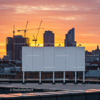 City Skyline with Construction Cranes and Sunset Sky