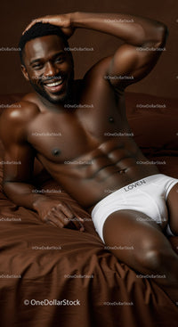 Smiling athletic man reclining on bed in white underwear