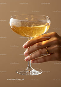 Hand Holding Elegant Champagne Glass with Bubbles