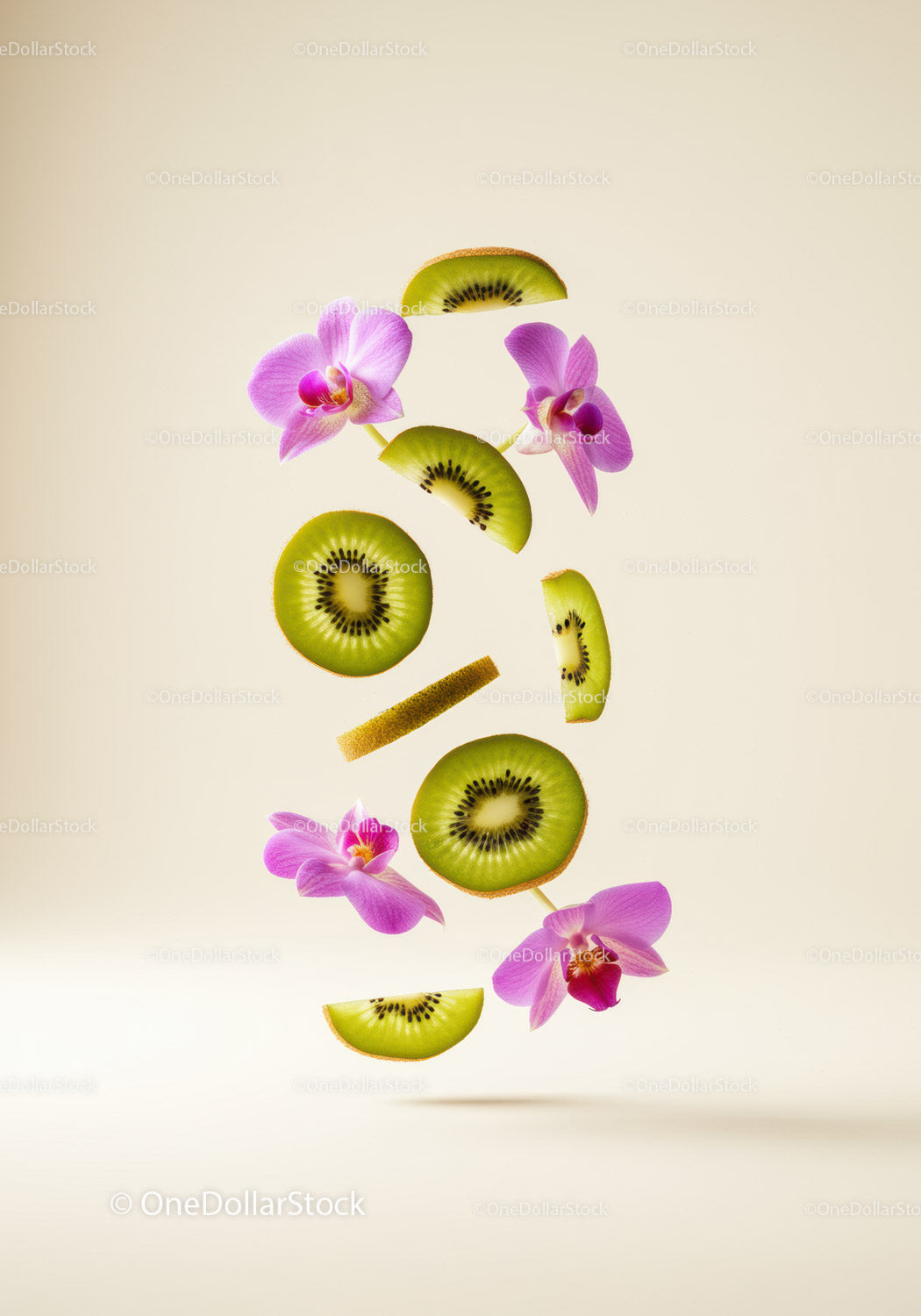 Fresh kiwi slices and pink orchid flowers floating on beige