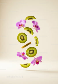 Fresh kiwi slices and pink orchid flowers floating on beige