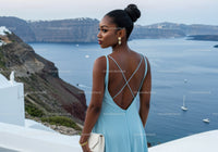 Elegant woman in blue dress overlooking scenic sea cliffs