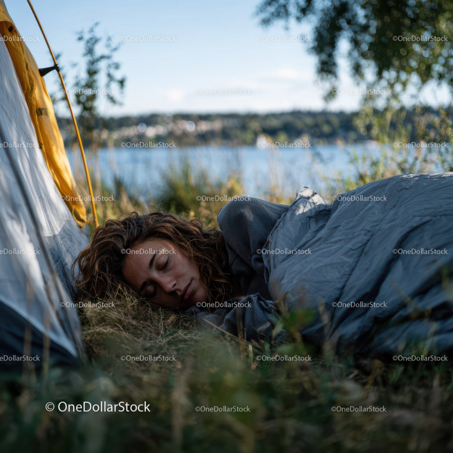 Young Woman Sleeping Peacefully by the Lakeside During Camping Trip