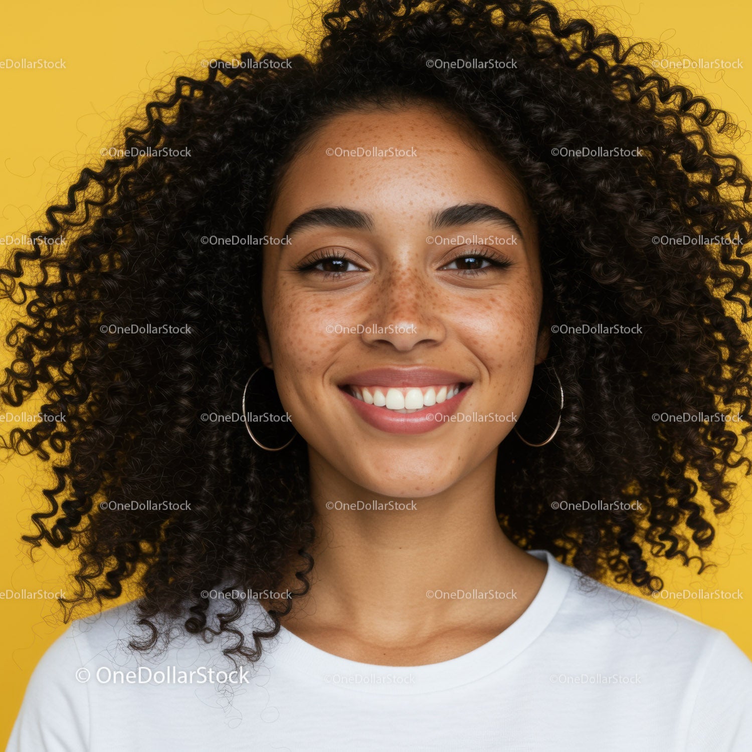 Portrait of a Happy Woman with Curly Hair and Freckles Against Bright Yellow Background