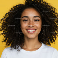 Portrait of a Happy Woman with Curly Hair and Freckles Against Bright Yellow Background