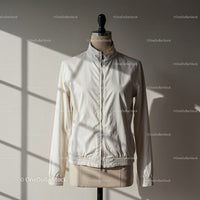 Minimalist white jacket on mannequin in soft sunlight