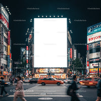 Busy nighttime city intersection with illuminated billboard