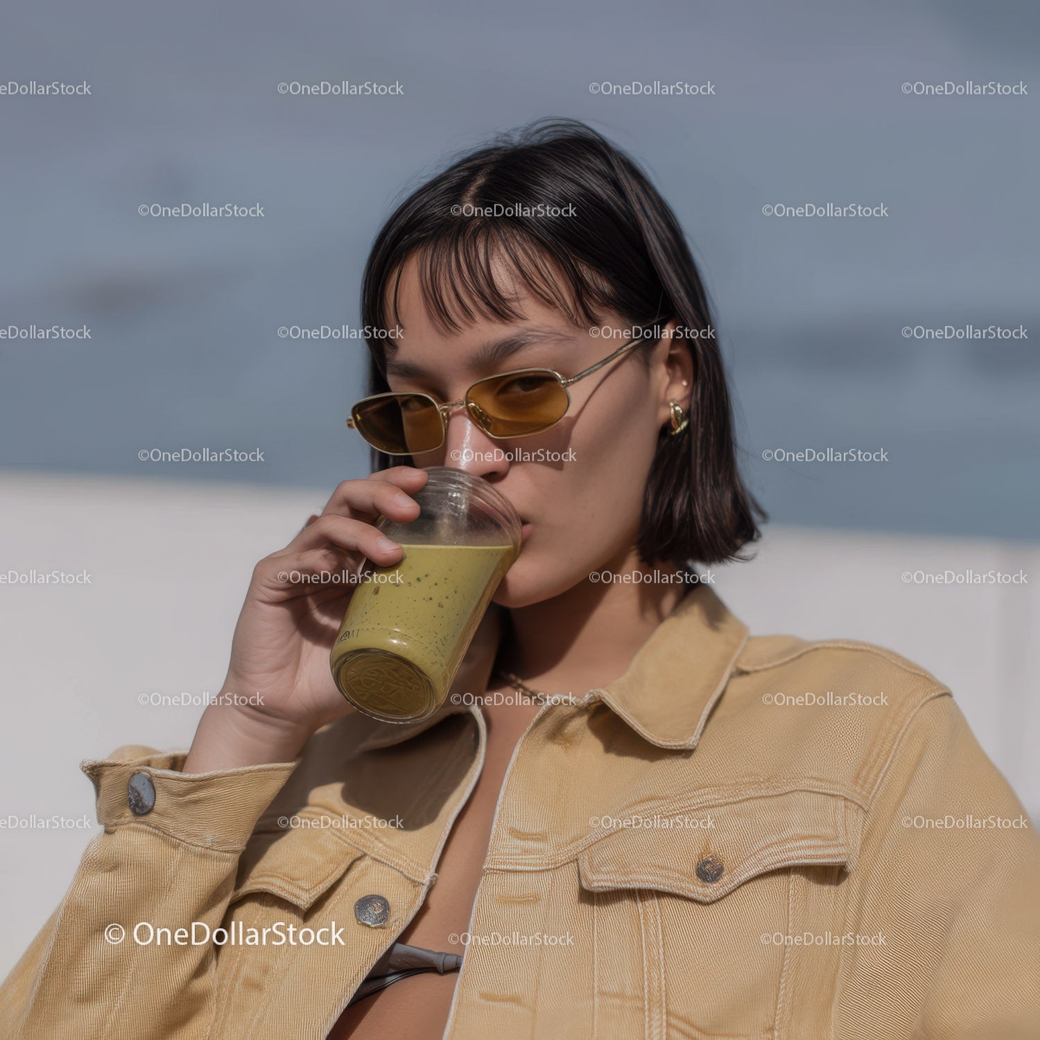 Young Woman Drinking Green Smoothie in Urban Outdoor Setting