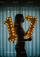 Silhouette of Woman Holding Lighted Number Balloons 17