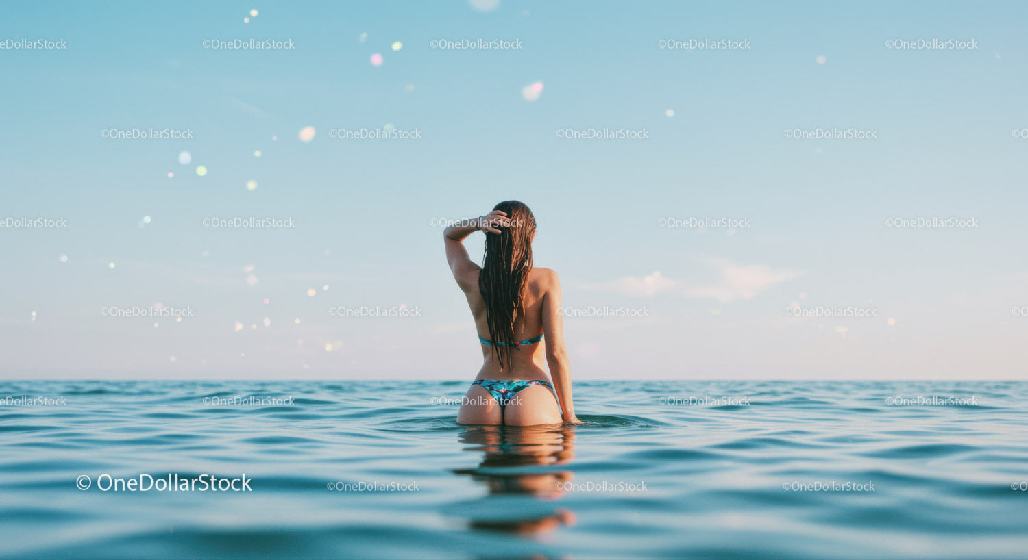 Woman in Bikini Relaxing in Calm Blue Ocean Under Clear Sky