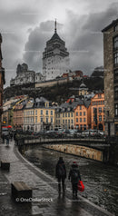Gothic Castle Tower Over Historic Cityscape with Colorful Houses