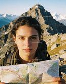 Young woman holding map in mountainous hiking adventure