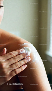 Applying Moisturizer to Bare Shoulder for Smooth Skin