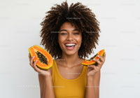 Happy Woman Holding Fresh Papayas with Bright Smile and Curly Hair