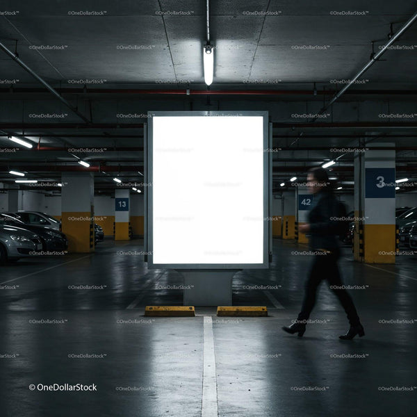 Blurred pedestrian walking past illuminated billboard in parking garage JPG Mockup Image