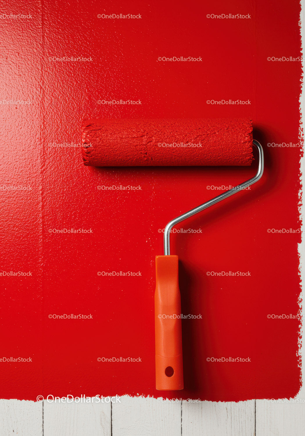 Red Paint Roller Applied to Wall for Home Renovation