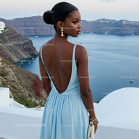 Elegant woman in blue dress overlooking sea cliffs