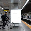 Cyclist passing empty advertisement in modern subway station