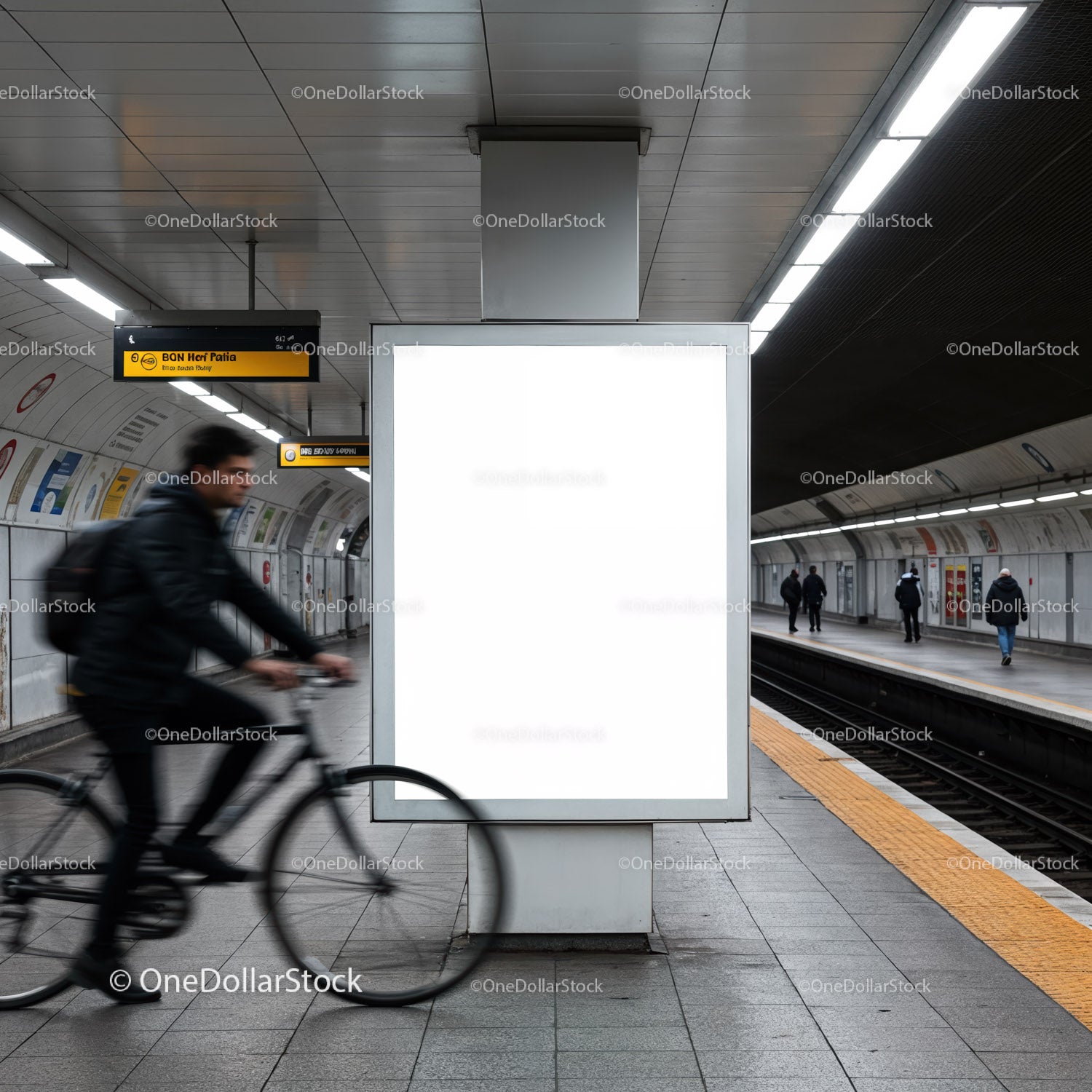 Rowerzysta mija pustą reklamę na nowoczesnej stacji metra