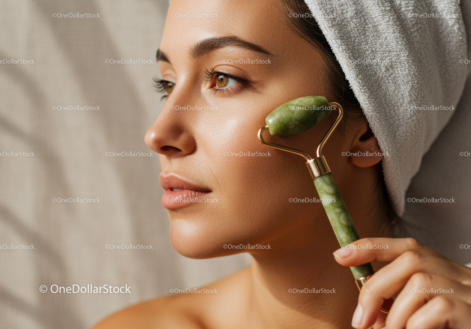 Woman Using Jade Roller for Facial Massage With Beautiful Skin and Towel