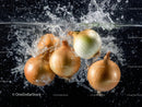 Fresh Onions Falling into Water Creating Splash and Bubbles