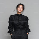 Elegant Woman in Black Shiny Dress with Statement Earrings