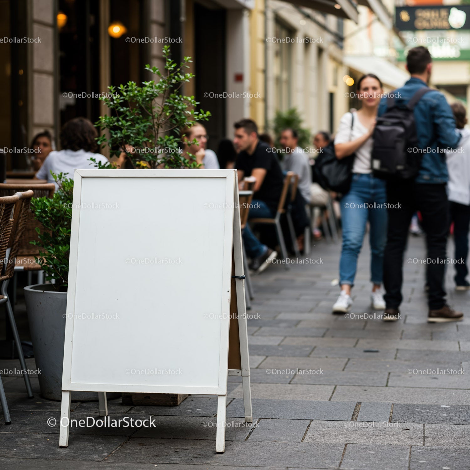 Pusta, biała tablica reklamowa na ruchliwej ulicy z kawiarniami na świeżym powietrzu