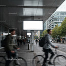 Urban commuters cycling past blank city billboards