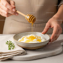 Close-Up of Honey Drizzling onto Yogurt in a Rustic Kitchen