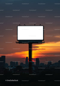 Empty illuminated billboard at sunset over cityscape skyline
