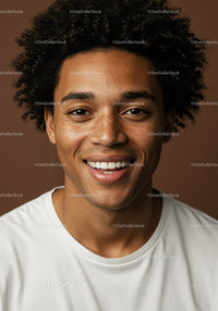 Young Man with Curly Hair and Freckles Smiling in Studio Portrait