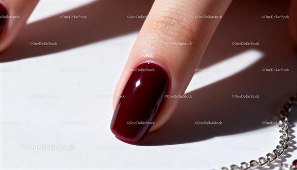 Close-up of Finger with Glossy Dark Red Nail Polish