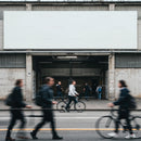 Blurred pedestrians and cyclists moving past urban garage entrance