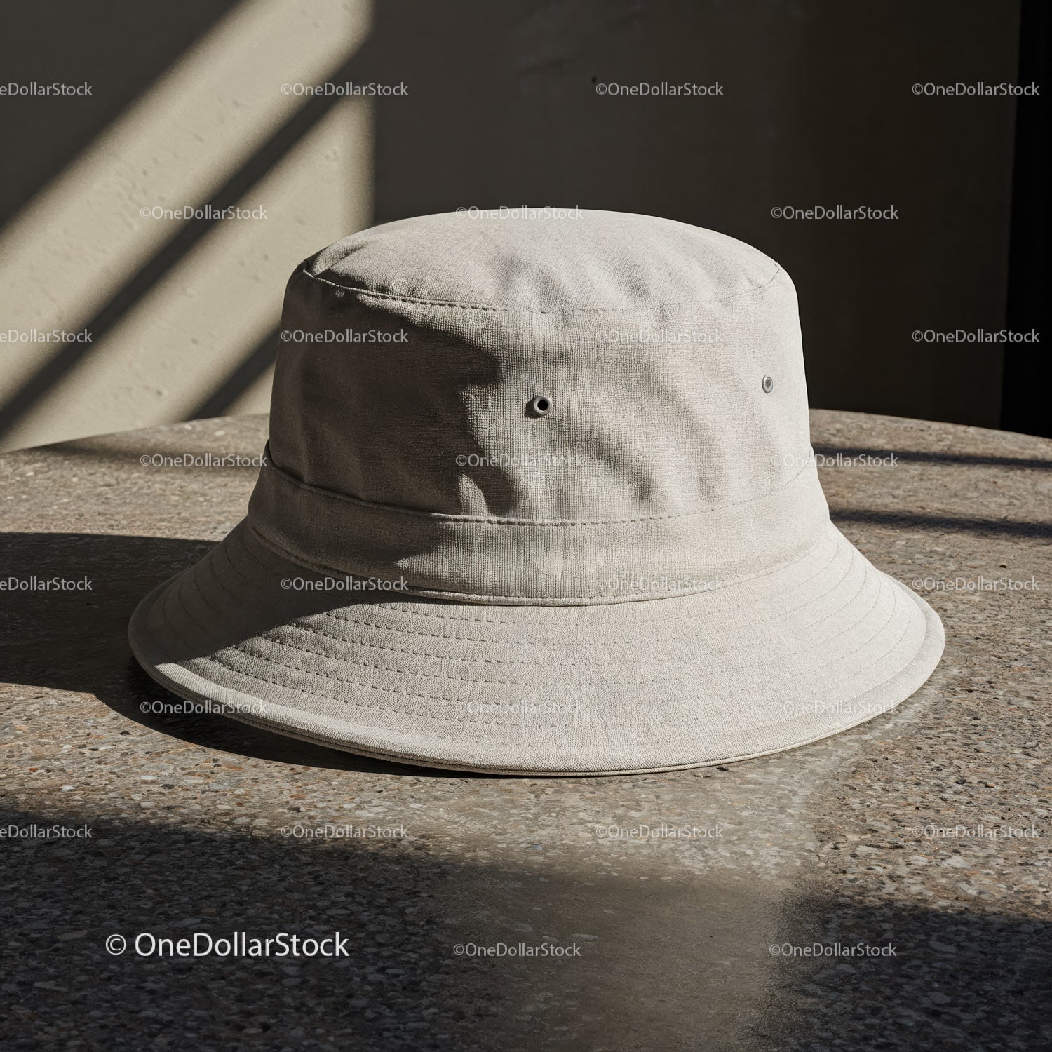 Beżowy bawełniany kapelusz typu bucket na kamiennym stole w delikatnym świetle