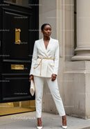 Elegant woman in white suit with gold chain belt