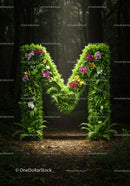 Green Letter M Made of Lush Leaves and Colorful Orchids