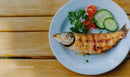 Fresh Grilled Fish with Cucumber Tomatoes and Parsley on White Plate