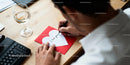 Man writing romantic message on heart-shaped card