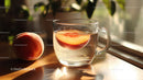 Peach Slices in Glass Cup of Water on Wooden Surface