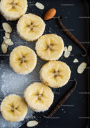 Sliced Bananas with Vanilla Beans and Almonds on Black Plate