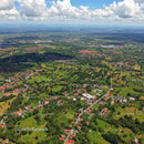 Green Landscape with Trees and Suburban Homes Under Blue Sky