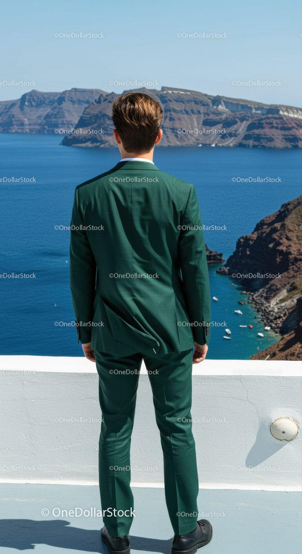 Man in Green Suit Overlooking Blue Sea and Rocky Cliffs