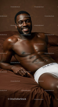 Smiling muscular man relaxing on brown bed sheets