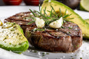 Juicy Grilled Steak with Fresh Avocado and Garlic on White Plate