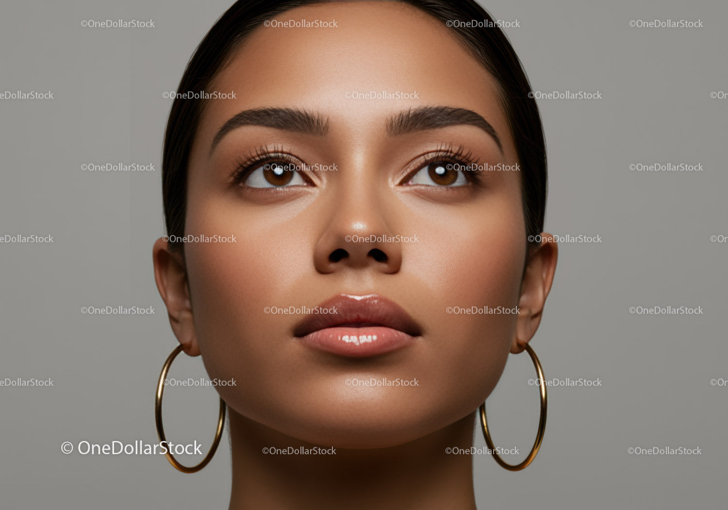 Portrait of a Woman with Brown Eyes and Glossy Lips in Gray Background