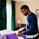 Man folding laundry in a cozy sunlit bedroom