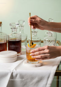 Elegant Cocktail Preparation with Orange Garnish in Modern Bar Scene