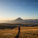 Scenic Mountain Landscape with Hiker Walking Through Golden Grass