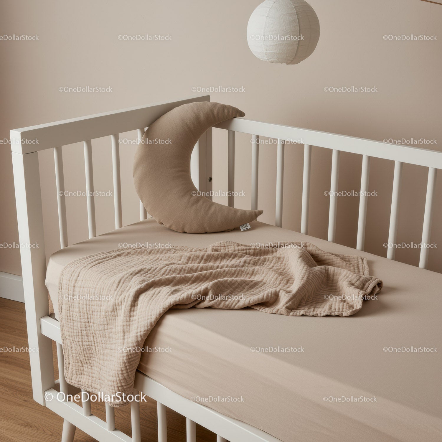 Cozy beige baby crib with crescent pillow and blanket