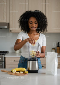 Young Woman Preparing Banana Smoothie in Modern Kitchen